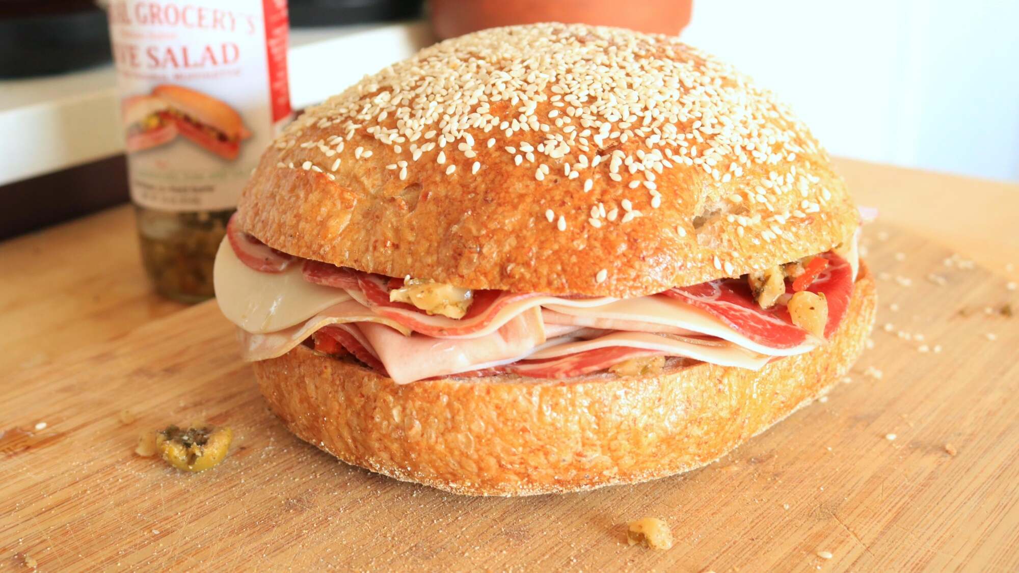 Complete muffuletta sandwich on a cutting board.