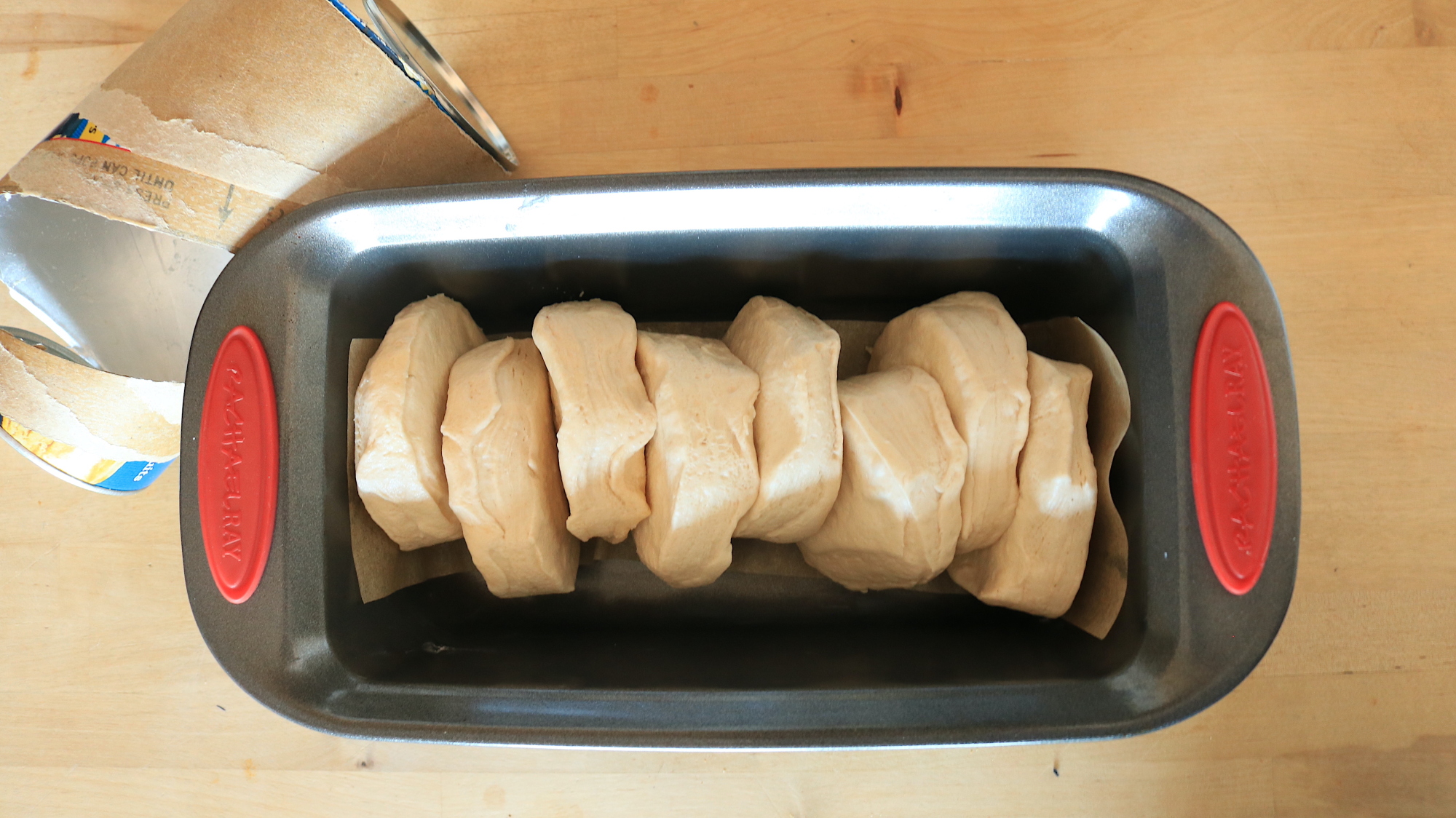 Raw biscuits stacked into a loaf pan.