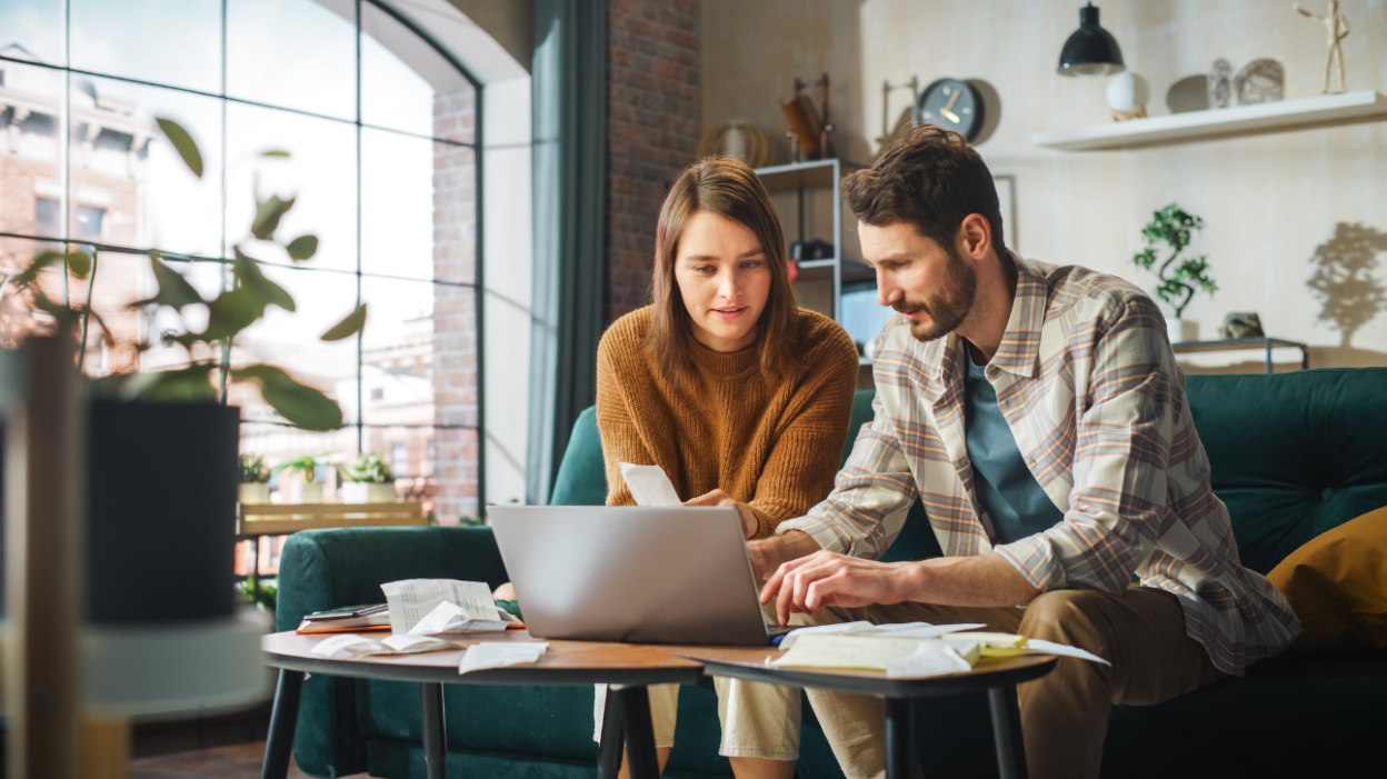 Couple in apartment working on laptop.