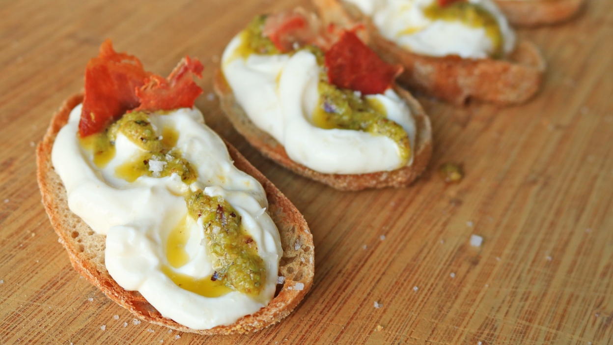 Whipped ricotta dizzled with pesto on toast.