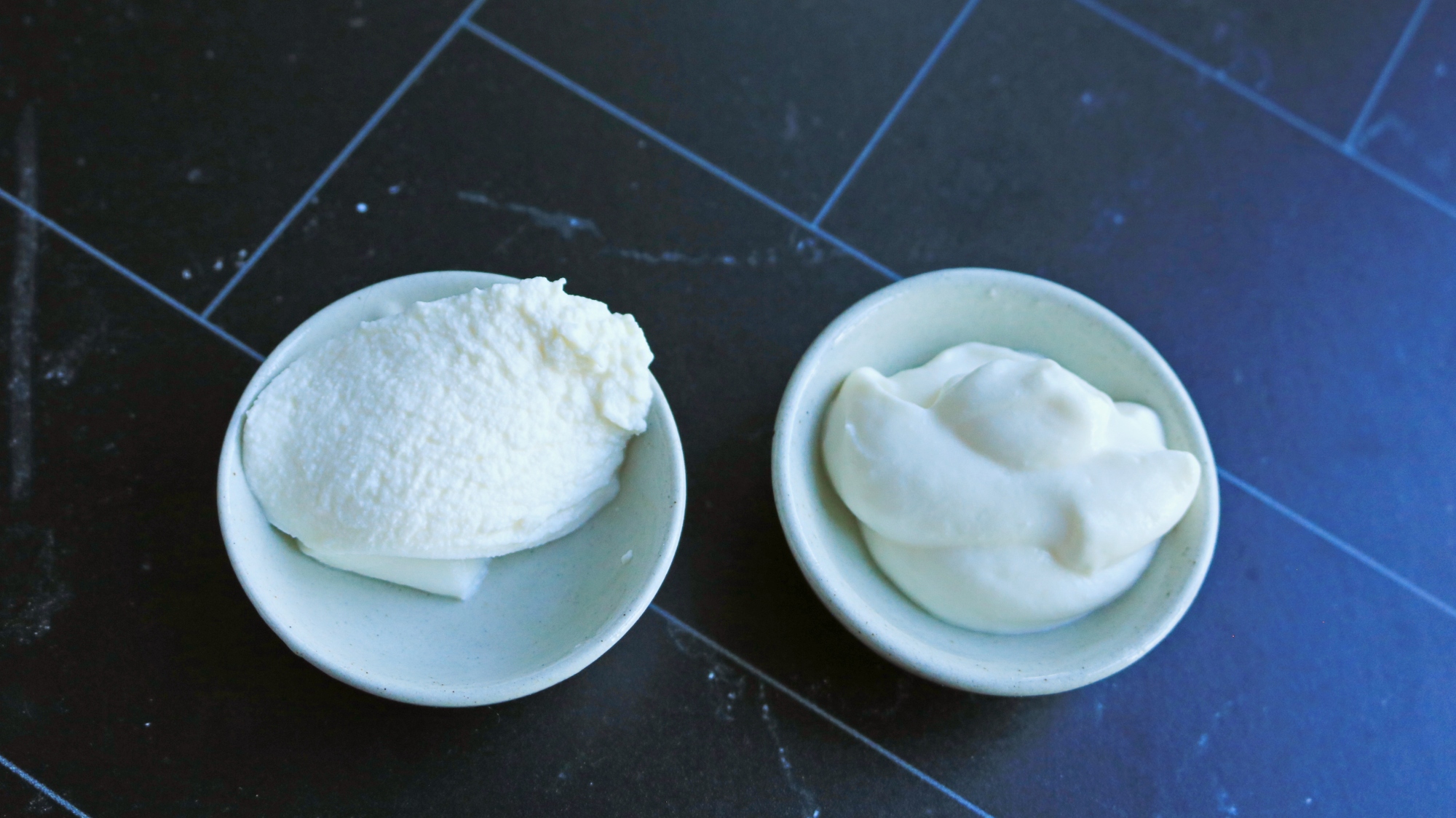 Two small bowls of ricotta cheese next to each other.