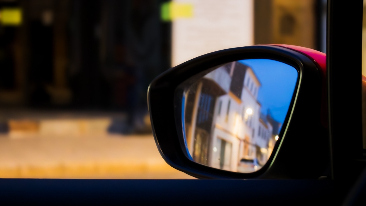 house as seen through car rear-view mirror