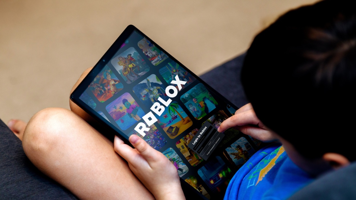 Child playing Roblox game on a tablet.