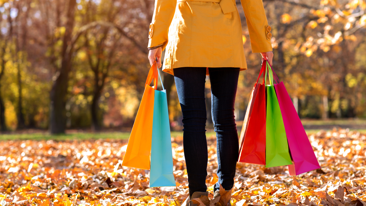 Woman holding colorful shopping bags in autumn