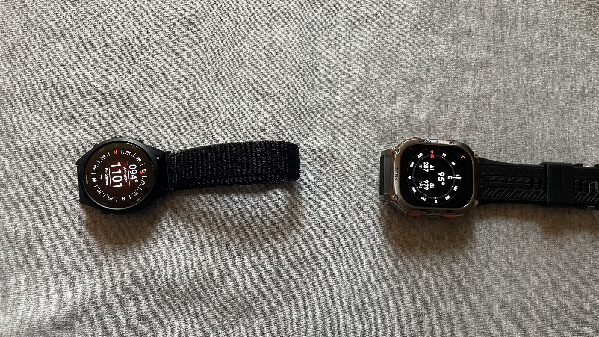 Two watches showing matching(ish) compass and barometer readings